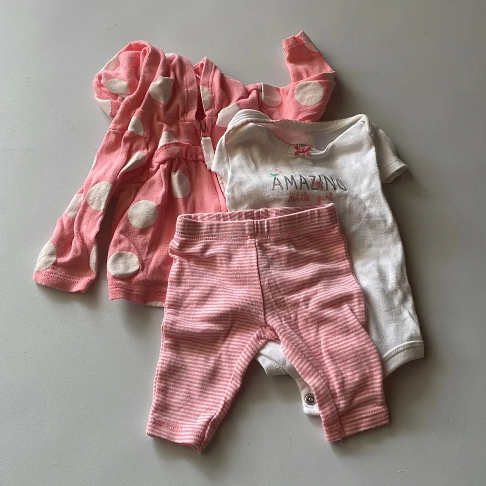 Carter’s three piece newborn set pink with white polkadots and striped pants.